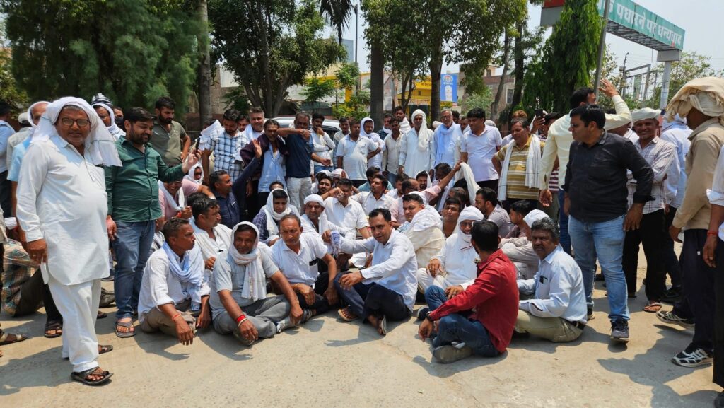 नरवाना नई अनाज मंडी में शनिवार को गेहूं उठान को लेकर मंडी एसोसिएशन के आढती नारेबाजी करते हुए ।