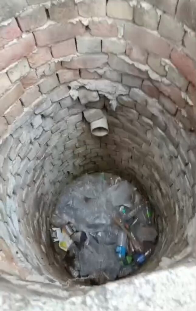 पटौदी शिव मूर्ति पार्क के पास फुटपाथ के किनारे कीचड़ भरा खड्डा और खुला कुआं